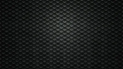 Rows of raised half-circles overlap like scales across a dark grey panel, the pattern brightest at the top and dimming toward the bottom.