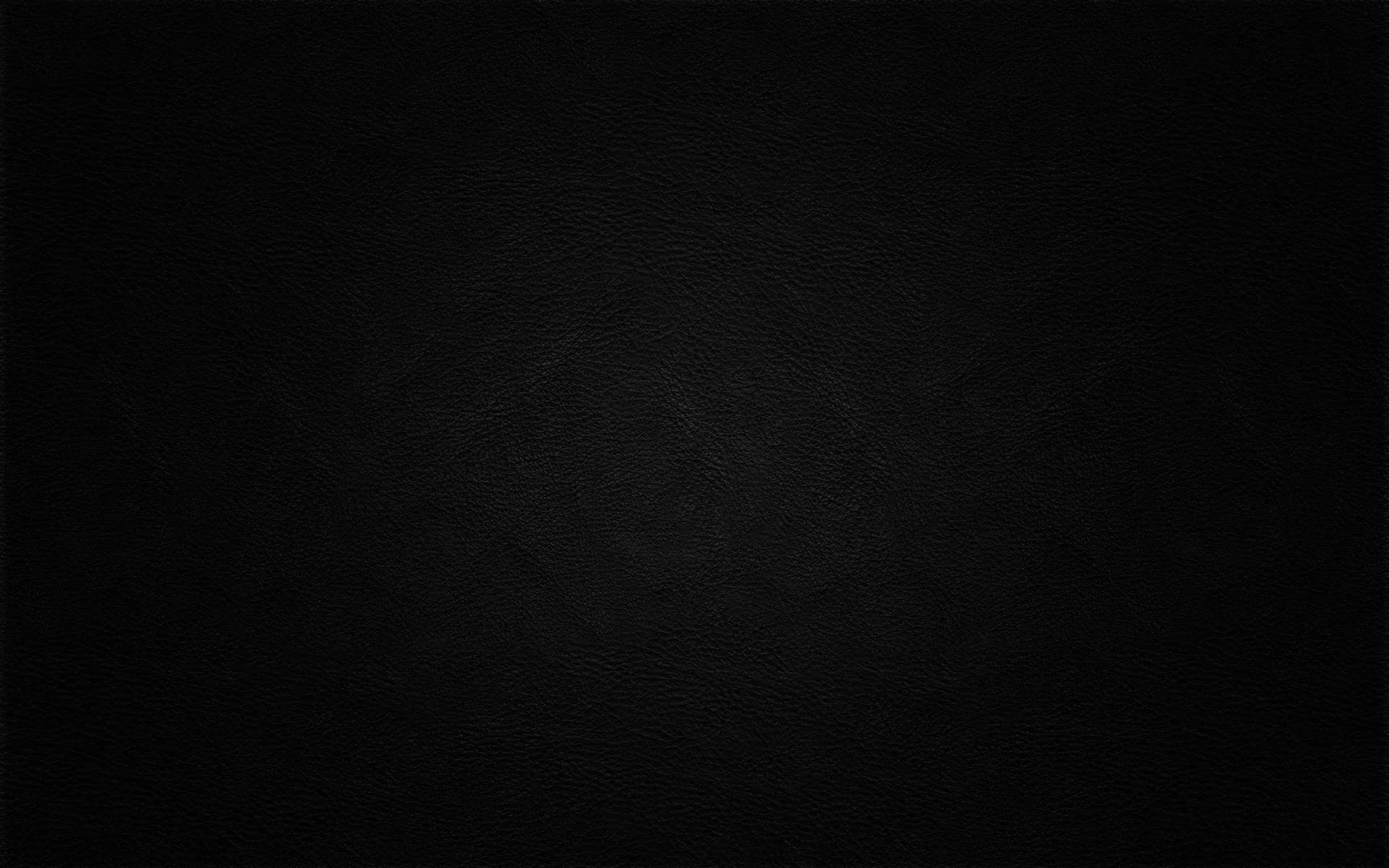 A soft round glow sits behind the middle of an otherwise black frame, faint enough that icons or text would sit over it cleanly.