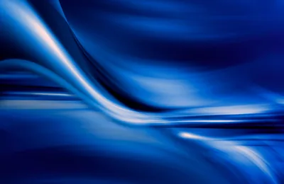 Satin-smooth waves of royal and navy blue roll across the whole frame, with the brightest white highlights gathered toward the left edge.