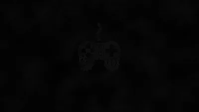 A gamepad sits almost entirely swallowed by black, only the faintest grey edge lighting hinting at its grips and thumbsticks.