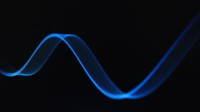A single ribbon of blue light bends through two smooth waves against solid black, brightest at the crest on the right.