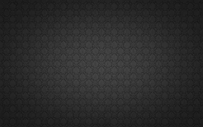 A small floral motif repeats evenly over charcoal, dimming steadily toward each corner of the frame.
