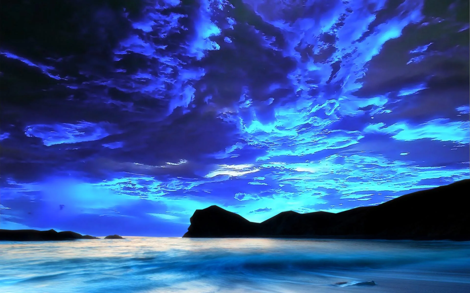 Ragged cloud fills the sky above a black headland, the sea below catching a pale sheen that carries down to the bottom of the frame.
