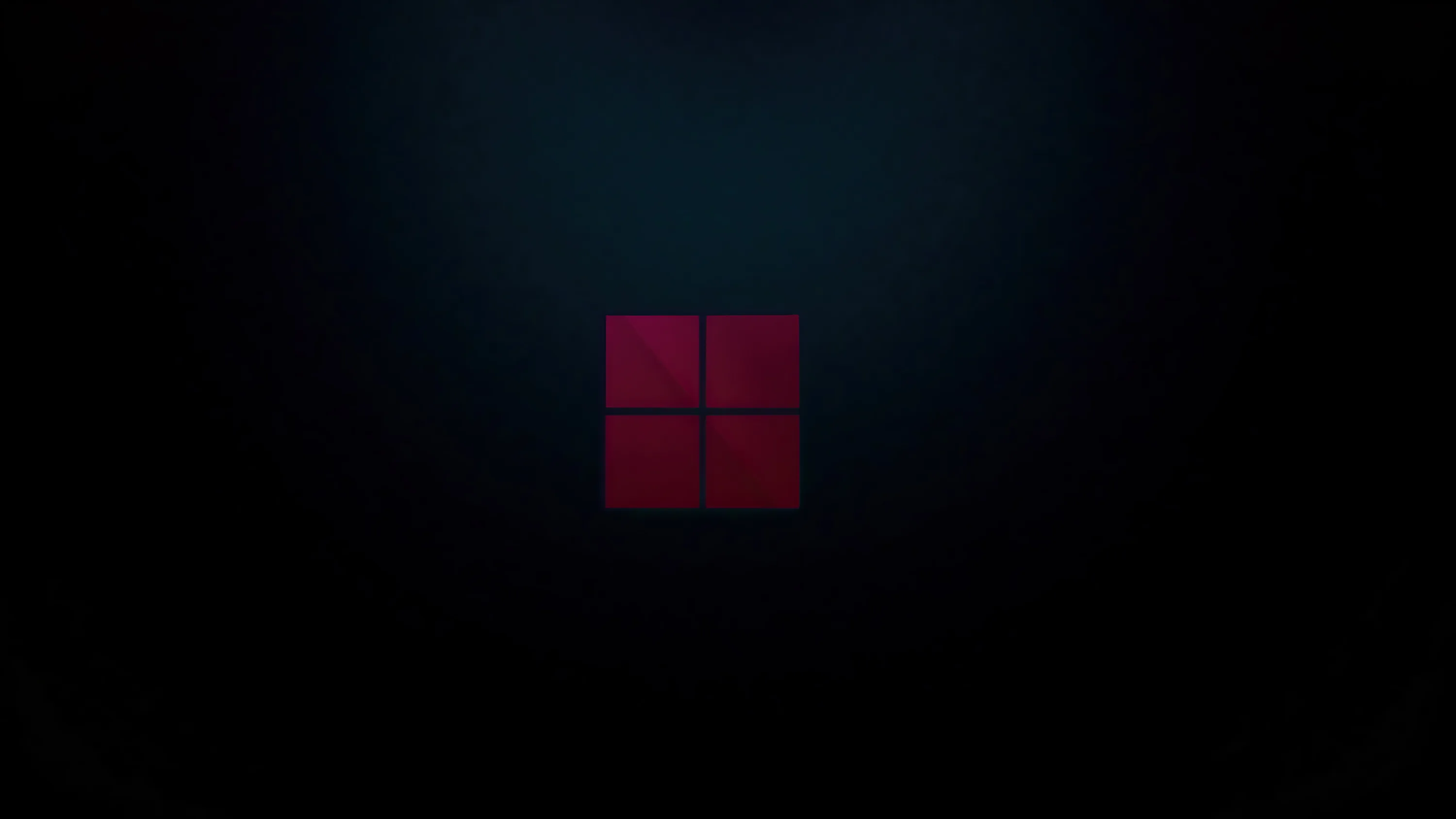 The four-pane Windows 11 mark glows dull red at the centre of an almost lightless room, a faint haze spreading around it.