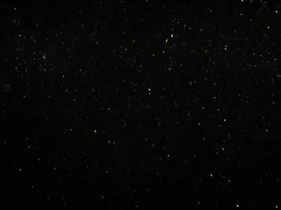 Almost the entire frame is flat black with small white stars scattered thinly across it — true #000000 for AMOLED screens.
