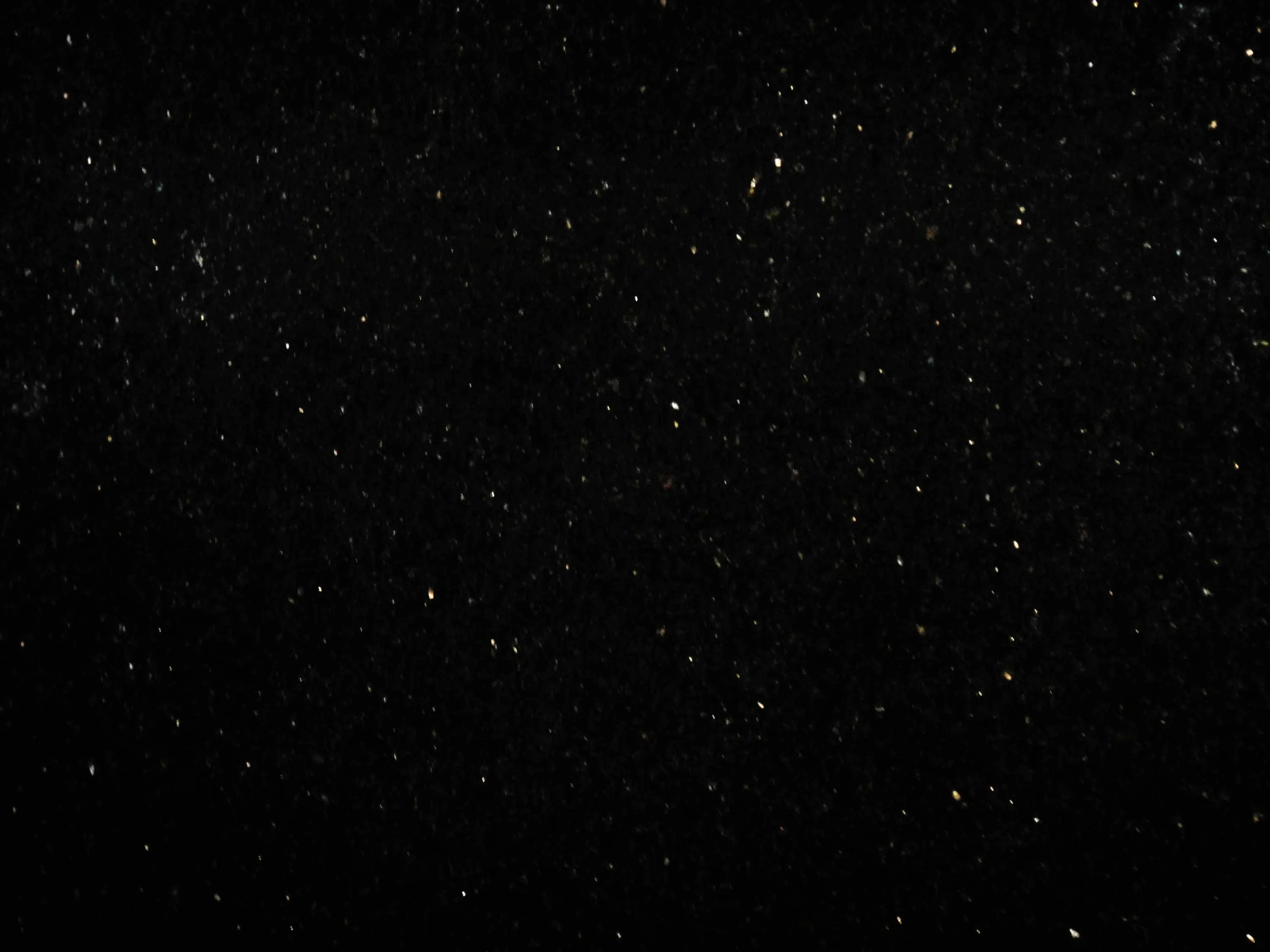 Almost the entire frame is flat black with small white stars scattered thinly across it — true #000000 for AMOLED screens.
