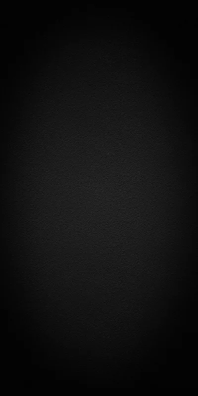 Fine grain over an almost solid black field, lifted very slightly toward the middle so the frame keeps its depth without any pattern.