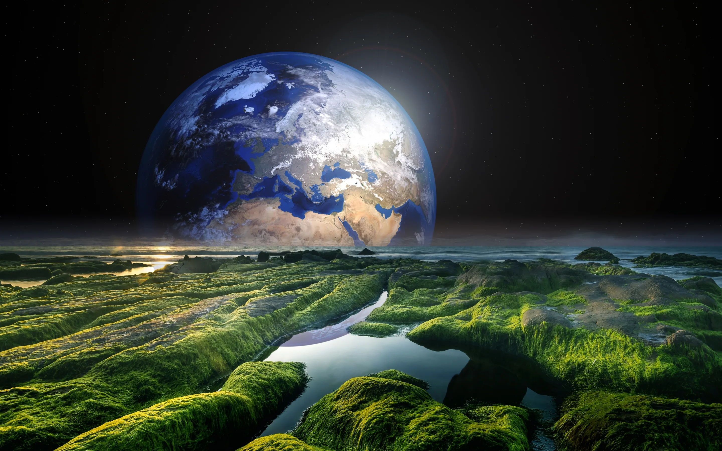 Water channels cut through moss-covered rocks while a half-lit Earth rises on the horizon, the dark sky above holding space for a menu bar.