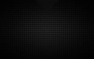 Hundreds of small raised squares fill the frame in matte black, brightest in a band across the upper middle with a heavy vignette pulling in the corners.
