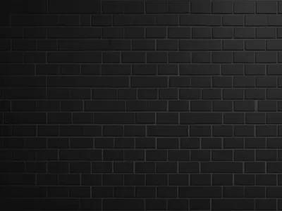 Small black bricks laid in tight even rows, a gentle wash of light along the top edge fading out before it reaches the lower corners.