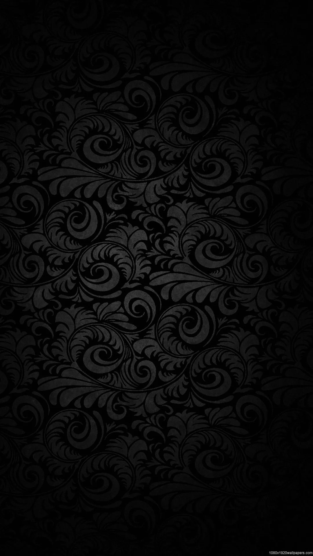 Curling damask scrollwork repeats down a tall near-black frame, the raised edges just bright enough to read against the ground.