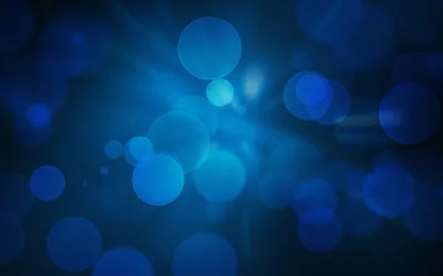 Soft out-of-focus circles drift across a deep blue field, the glow strongest near the top left and fading into near-black at the corners.