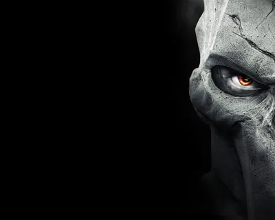 Death's cracked stone mask from Darksiders II fills the right half, one ember-orange eye glowing, while the left half stays pure black for icons.