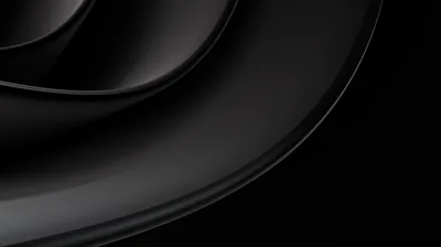 A smooth dark ridge sweeps in from the left corner, its edge catching light while the right half stays black.