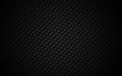 The crosshatched weave of carbon fibre in dark grey, evenly lit through the middle with the borders sinking into black.