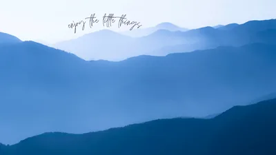 Ridge after ridge of mountains fade into pale blue haze toward the top, each layer a lighter step, the foreground slope holding the deepest tone.