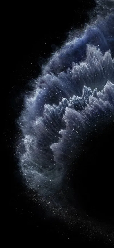 A towering wave of dark blue mist curls over from the top right, its spray breaking into speckles before the frame goes black.
