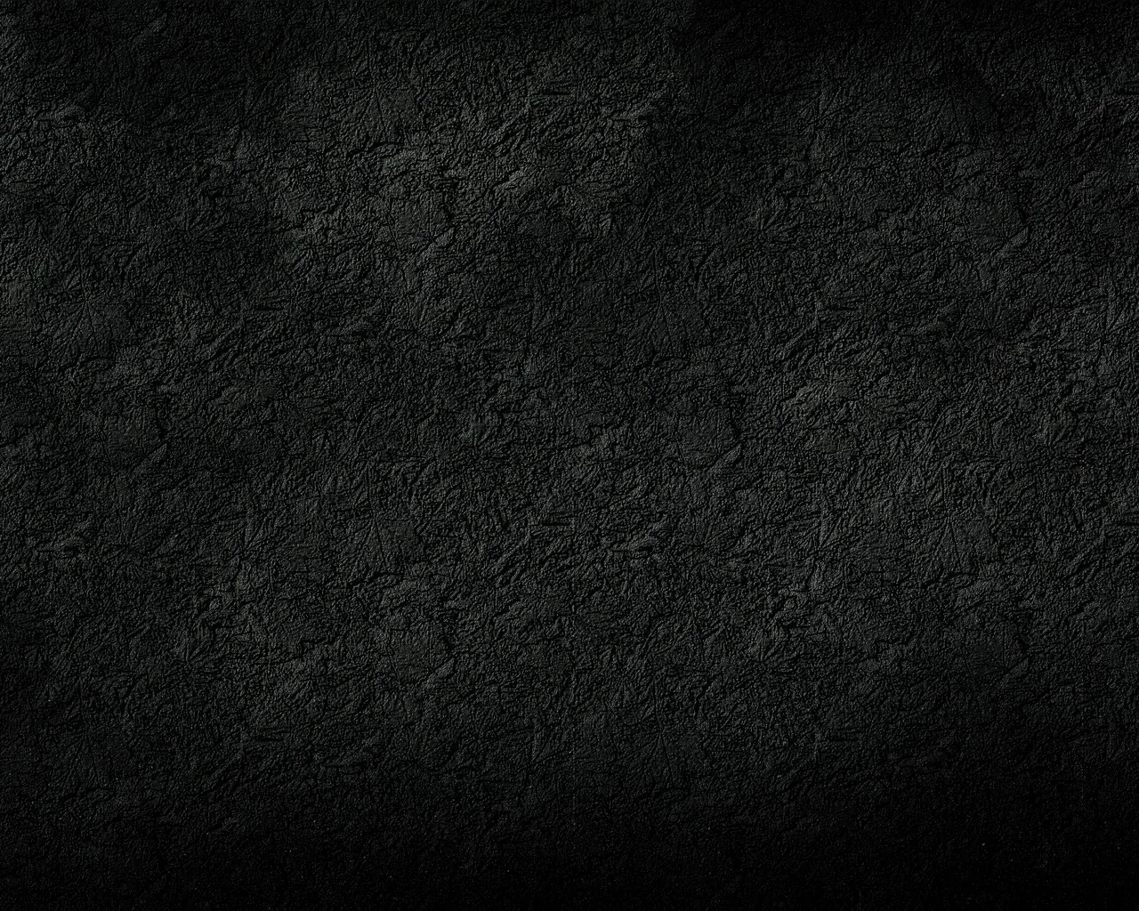 A charcoal plaster wall mottled with faint grey blotches, brightest just left of centre while every edge sinks to full black — icons stay readable anywhere along the border.