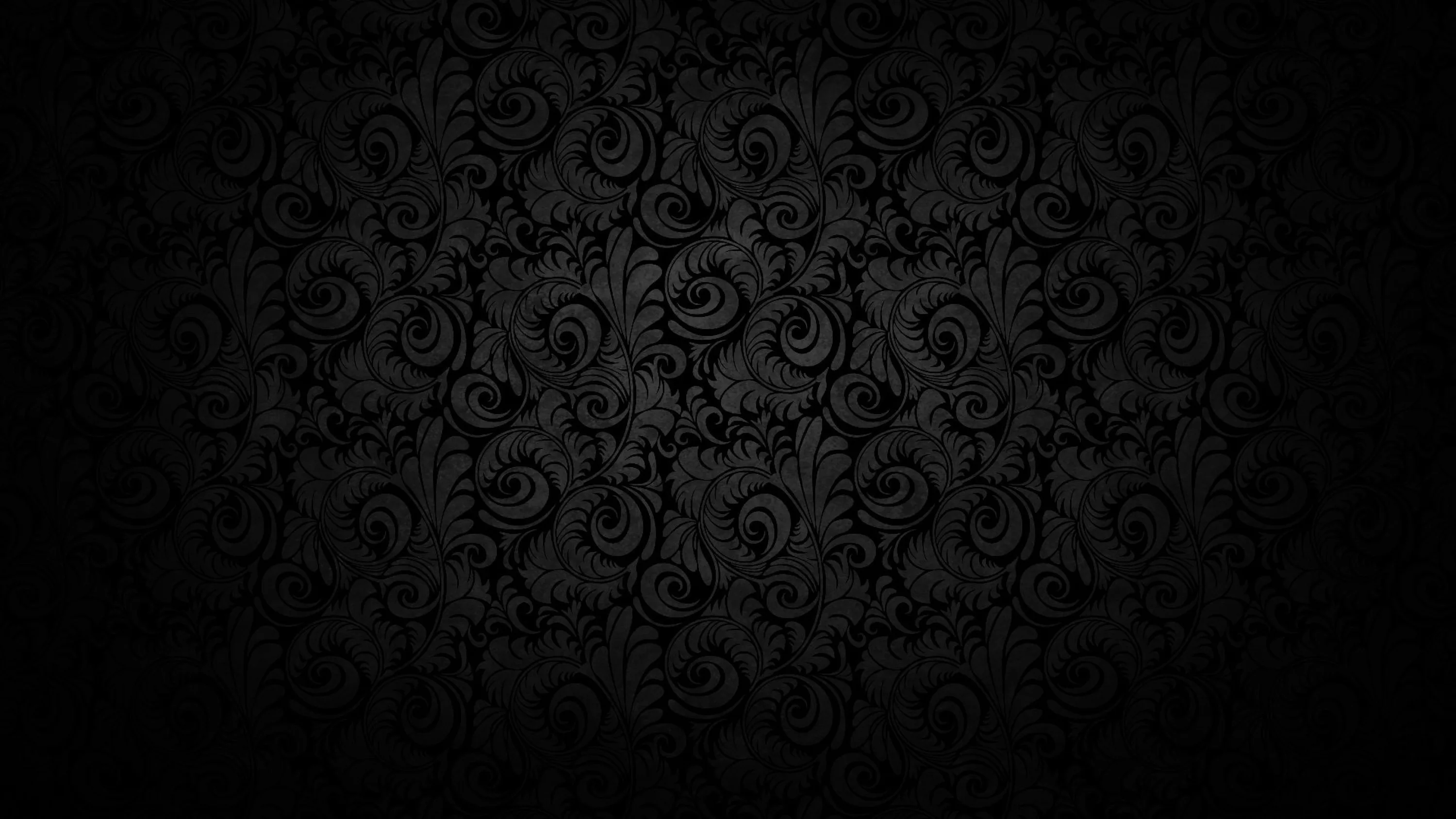 A baroque wall pattern shows through in the middle of the frame and dissolves into black toward every corner.