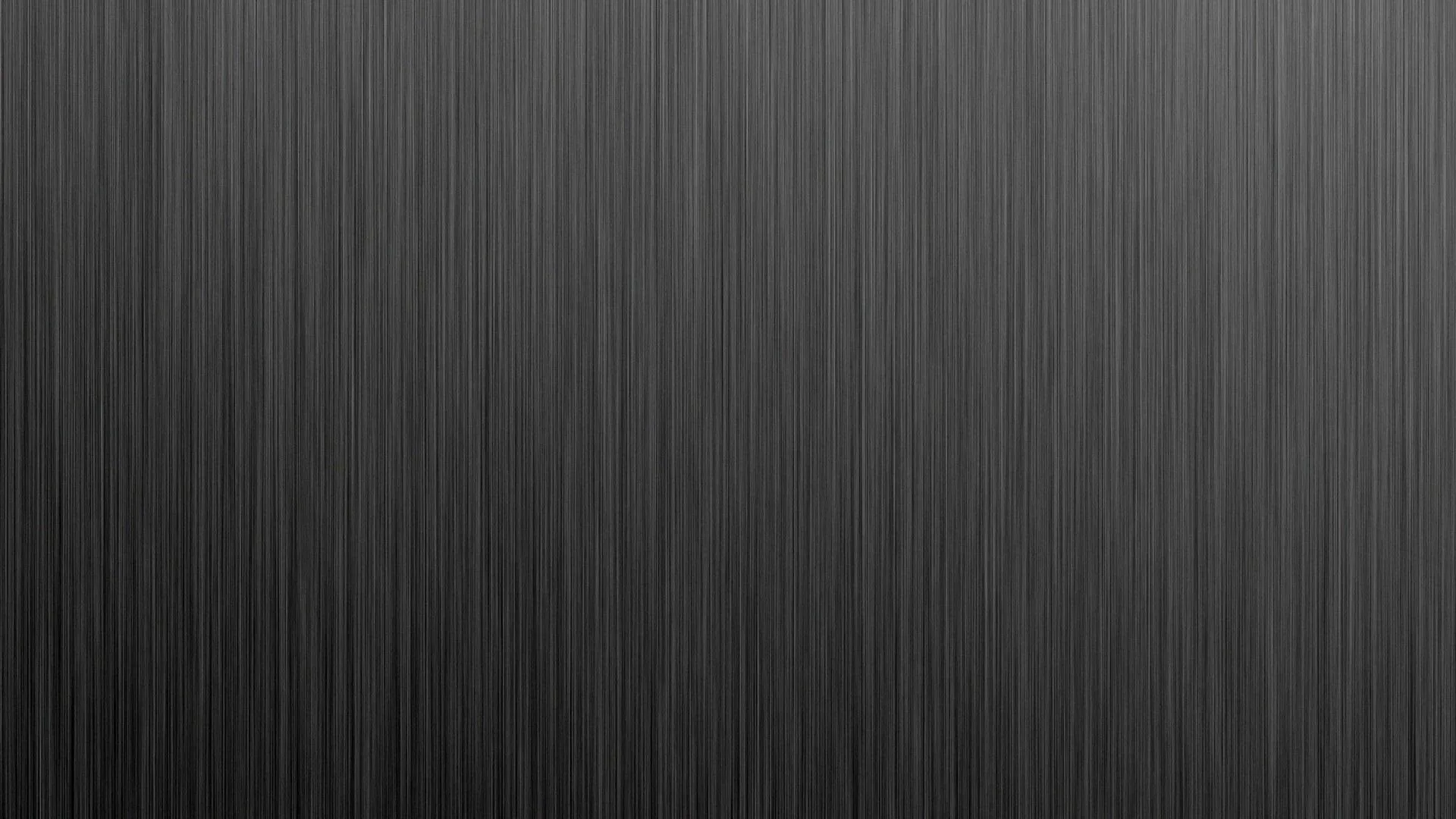 Fine vertical brushing runs top to bottom across a mid-grey panel, dimming slightly toward the lower left, with no focal point to fight your icons.
