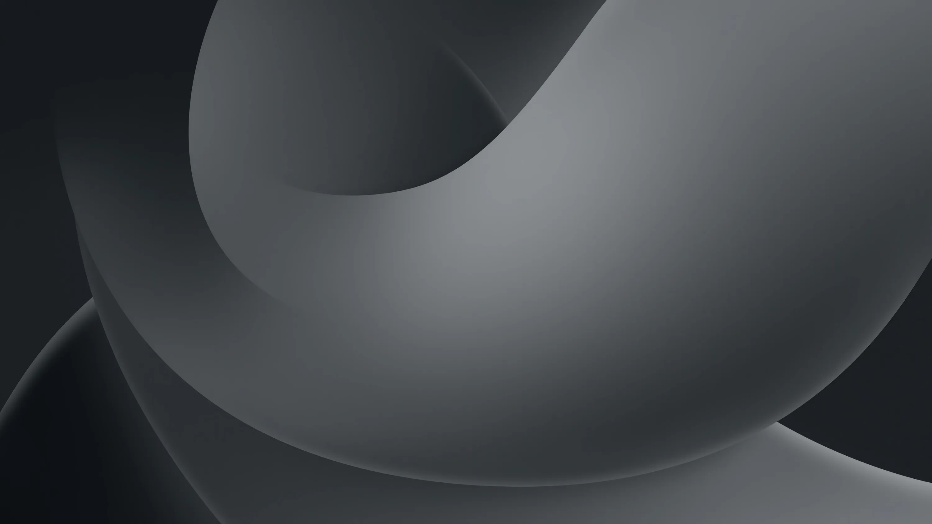A smooth grey form folds back into itself across a wide frame, the light rolling over its curve and dropping to near black at the far right.