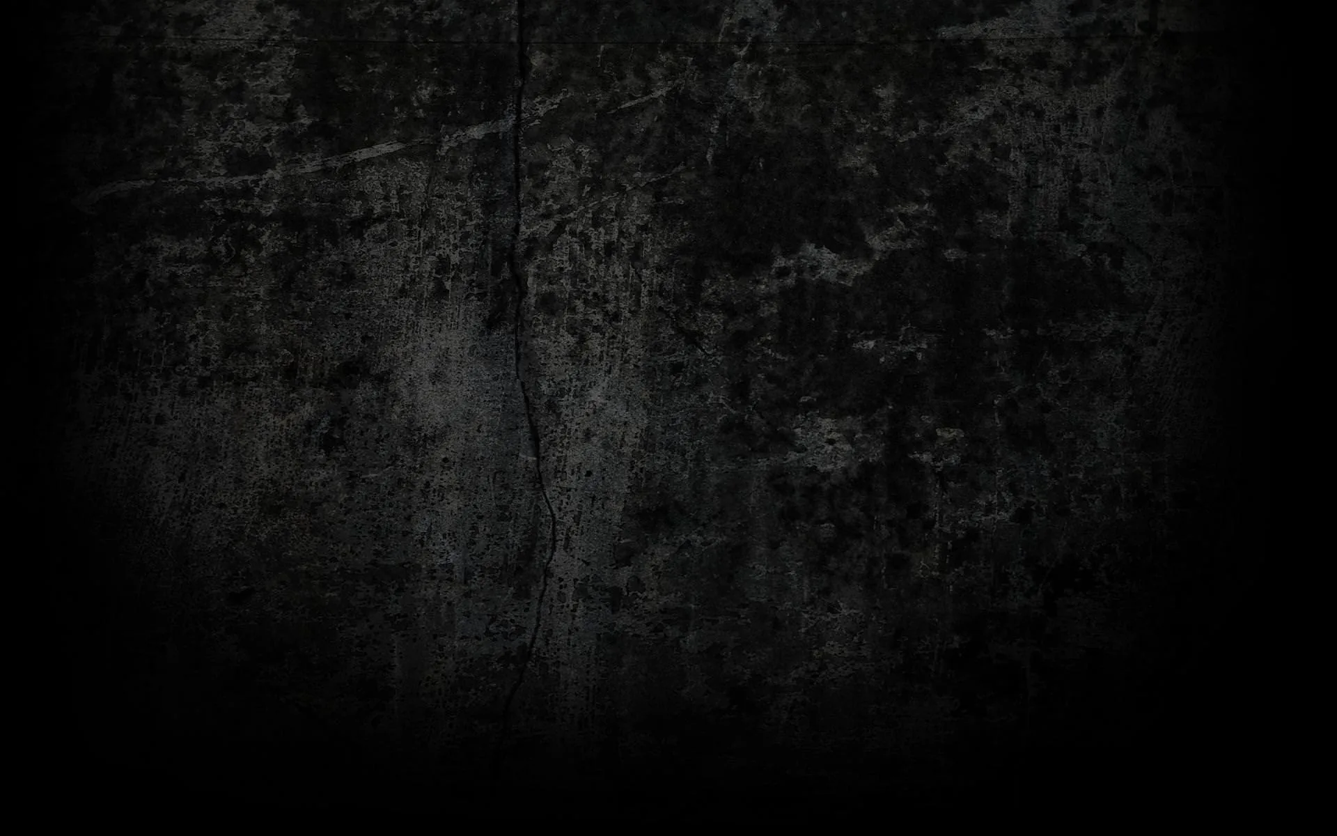 A weathered concrete surface holds its texture through the centre and drops off into full black at every edge.