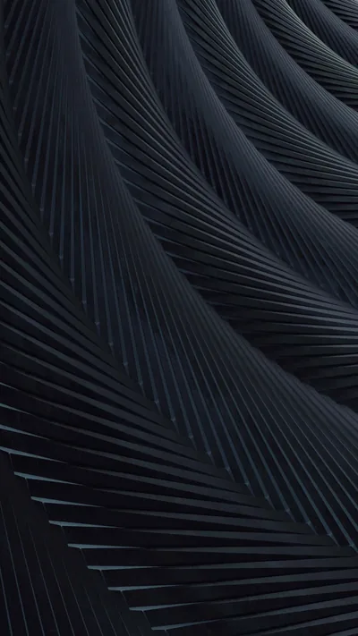 Fans of fine parallel ridges sweep diagonally through this tall frame in midnight blue, cool light catching the top-left crests while the ridges below go dark.