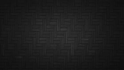 Dark tiles laid in herringbone repeat evenly across the frame, the seams brightening slightly through the middle.