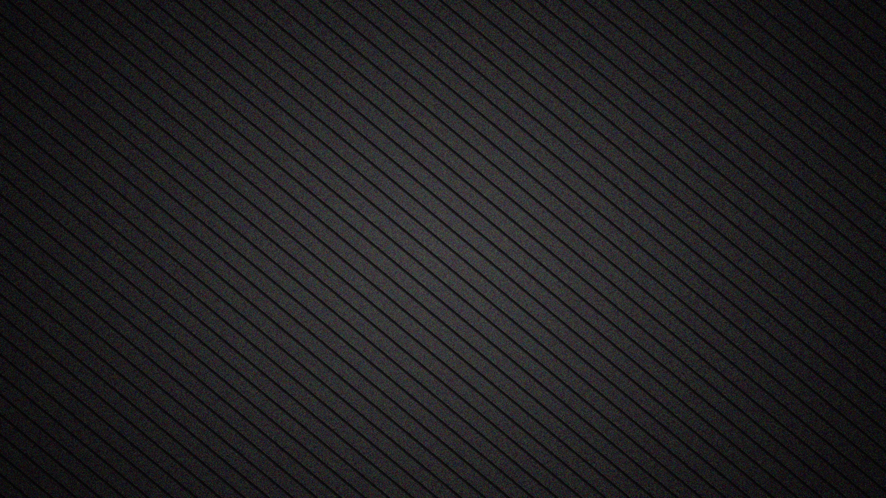 Fine diagonal stripes run corner to corner over a charcoal surface, the weave tightening near the top so the lower half reads almost solid.