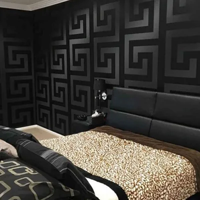 Matte Greek key pattern covers two bedroom walls in solid black, paired with a leopard-print throw across the bed.