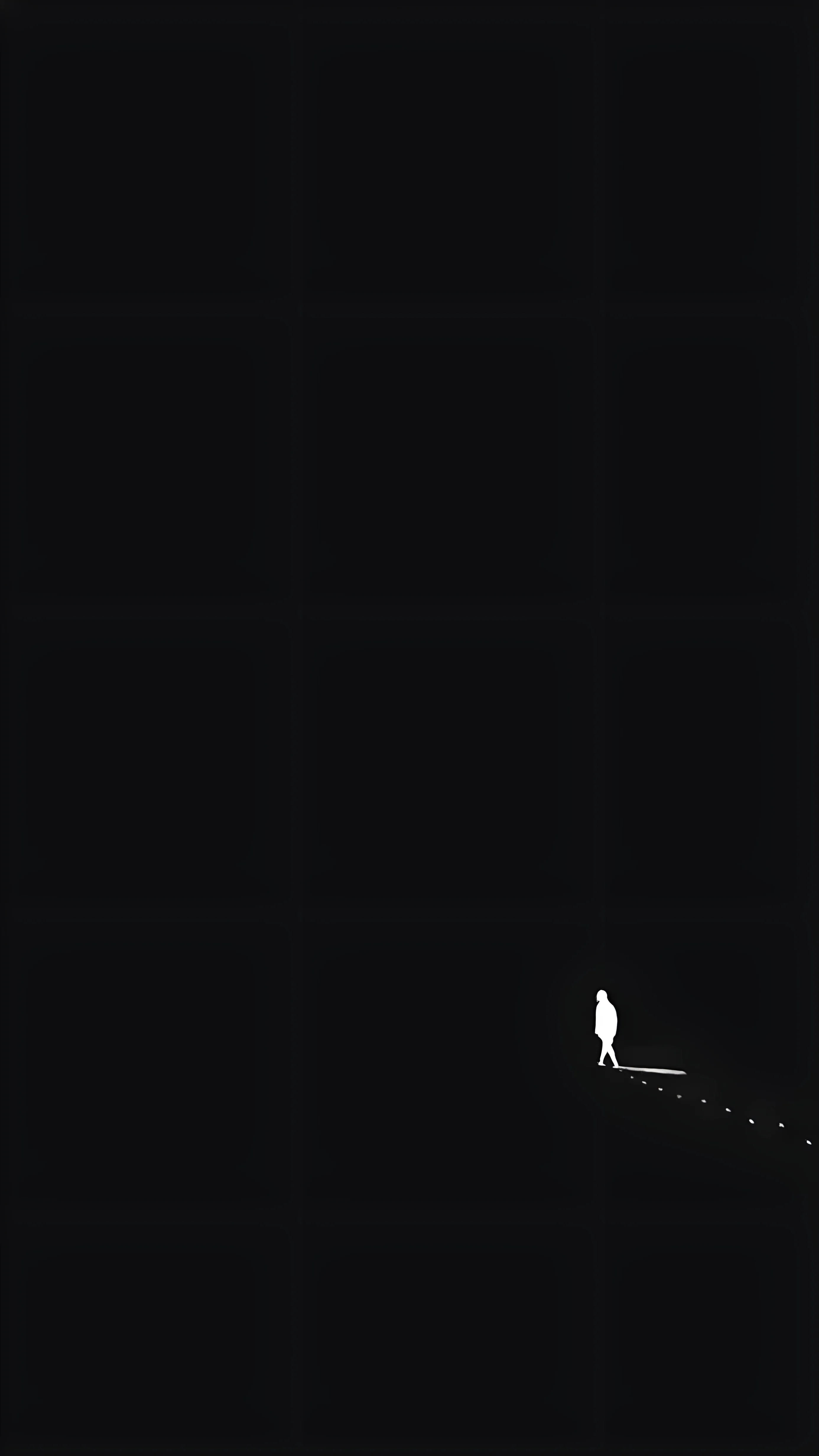A white silhouette walks a narrow lit strip near the bottom of a tall black frame, with nothing else visible above it.