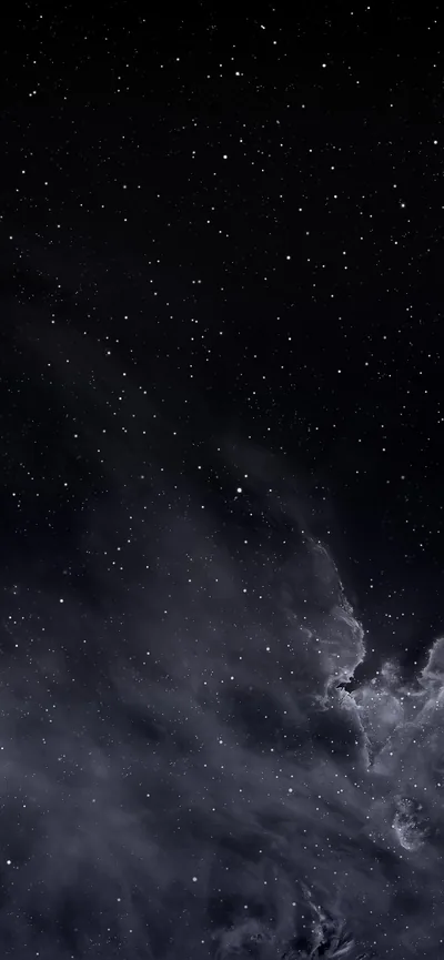 Scattered stars sit above a bank of pale cloud drifting in from the lower right, the rest of the night sky left almost black.