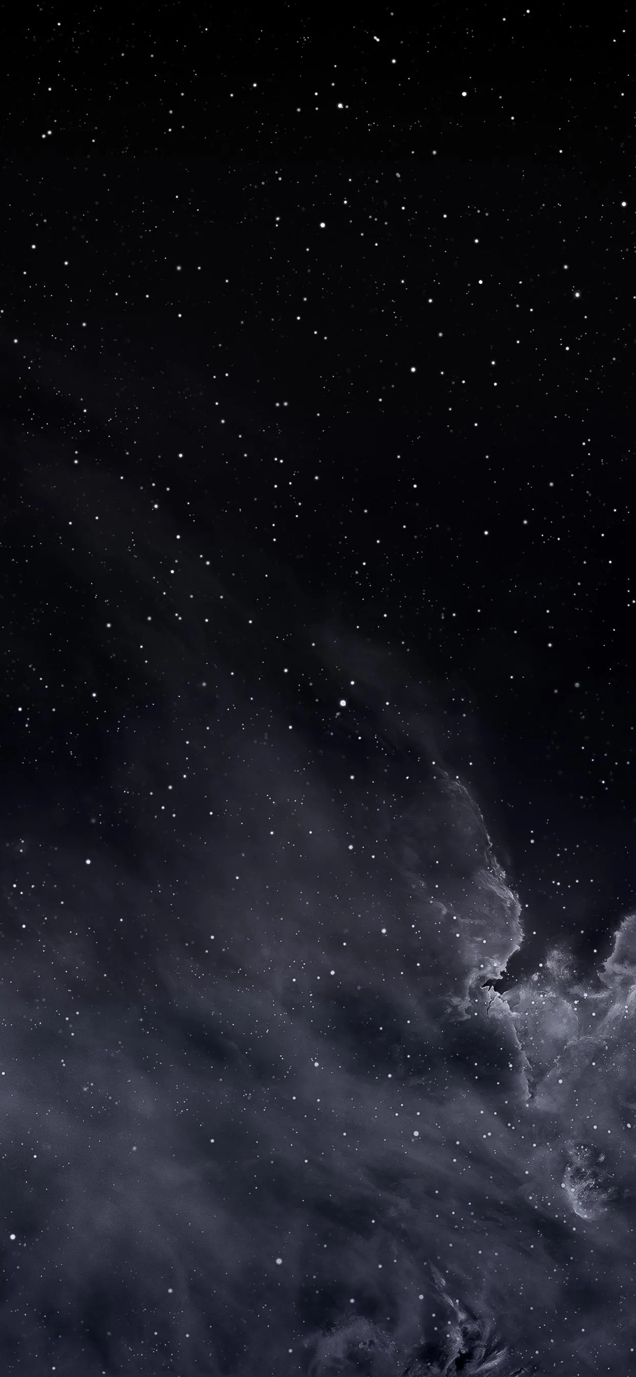 Scattered stars sit above a bank of pale cloud drifting in from the lower right, the rest of the night sky left almost black.