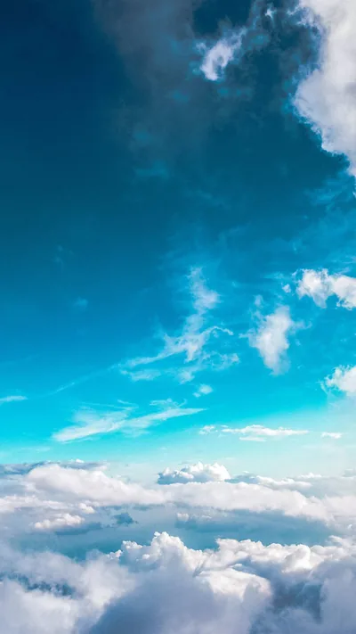 A vertical view down onto a cloud deck, turquoise sky filling the middle of the frame with clean space for widgets.