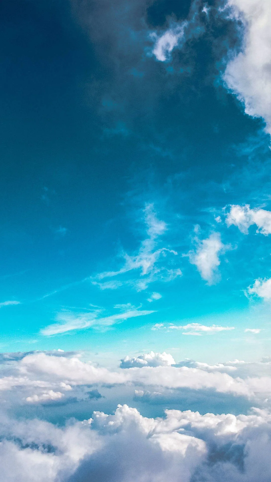 A vertical view down onto a cloud deck, turquoise sky filling the middle of the frame with clean space for widgets.