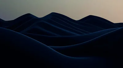 Smooth dark blue hills roll toward the horizon with the last warm light sitting along the top of the frame.