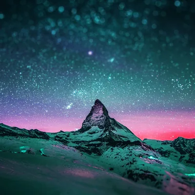 A snow-covered pyramid peak rises into a teal field of stars, a band of pink sunset glow pinned along the horizon behind the ridgeline.