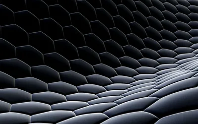 A honeycomb grid of raised hexagons rolls into a wave across the frame, the crests lit silver while the troughs stay in shadow.
