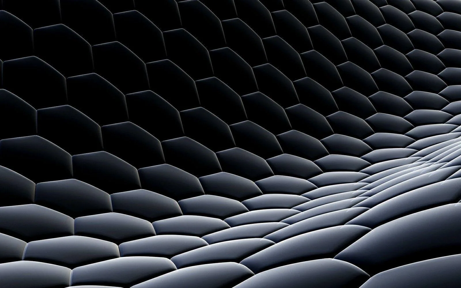 A honeycomb grid of raised hexagons rolls into a wave across the frame, the crests lit silver while the troughs stay in shadow.