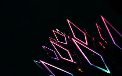 Bright pink, blue and violet diamond shapes stack diagonally across the frame, the rest left black.
