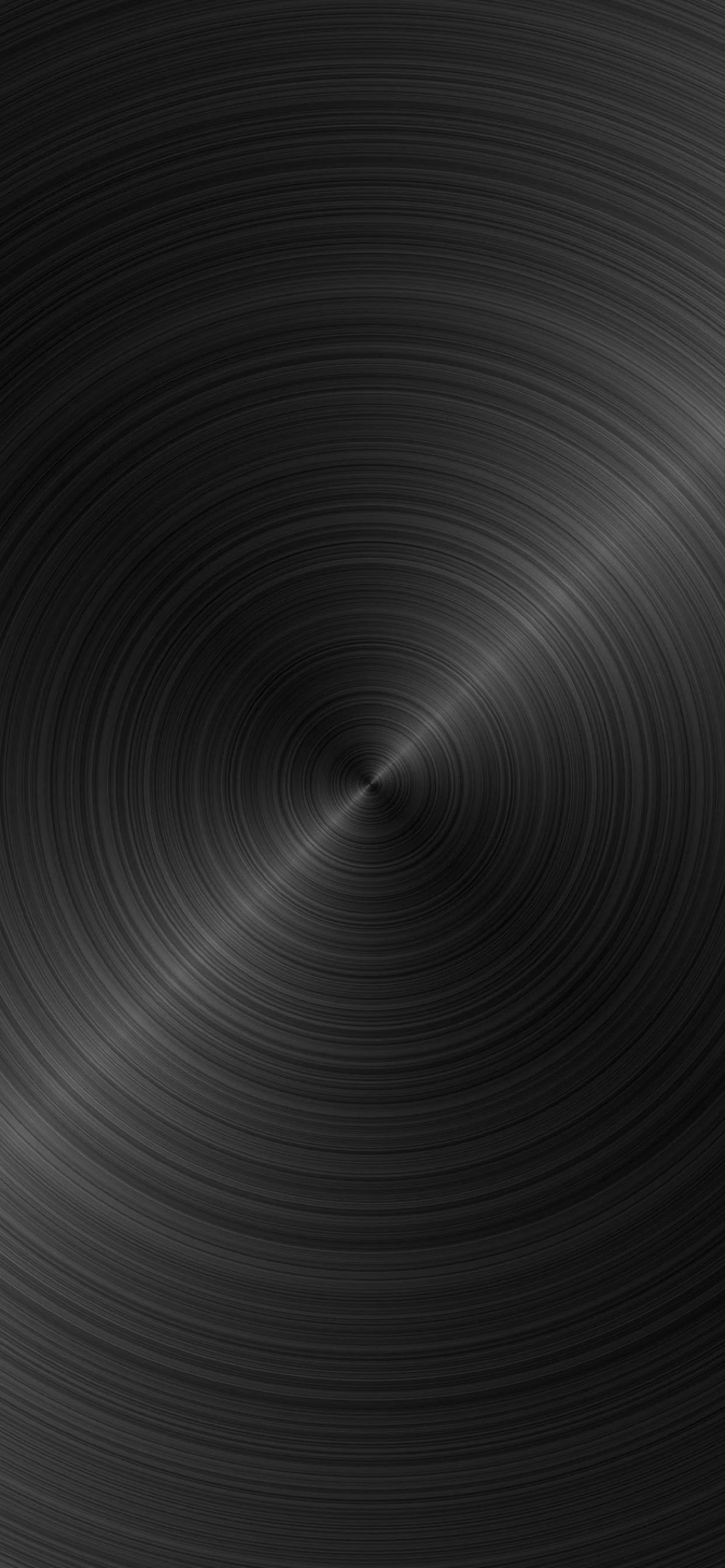 Concentric brush marks spin out from a point low in the frame, the metal reading almost black at the corners and faintly silver near the centre.
