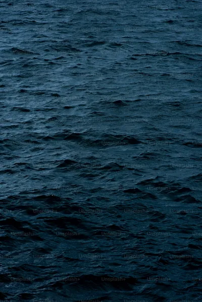 An even field of small choppy waves in slate blue, no single subject anywhere, so the whole frame works behind a full grid of home-screen icons.