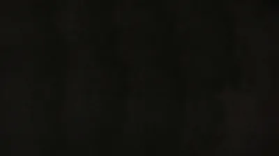 Barely visible vertical smudges run down a near-black surface, the kind of texture that only shows on a screen turned up bright.