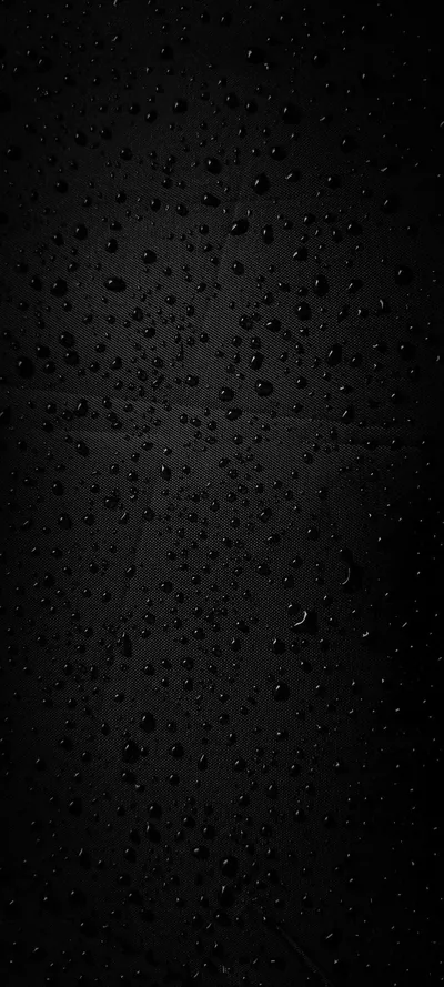 Fine beads of water cling to a black pane, denser through the middle and thinning out towards the corners.