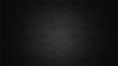 Horizontal wood grain fills the frame in charcoal, brightening slightly through the middle and dimming toward all four corners.
