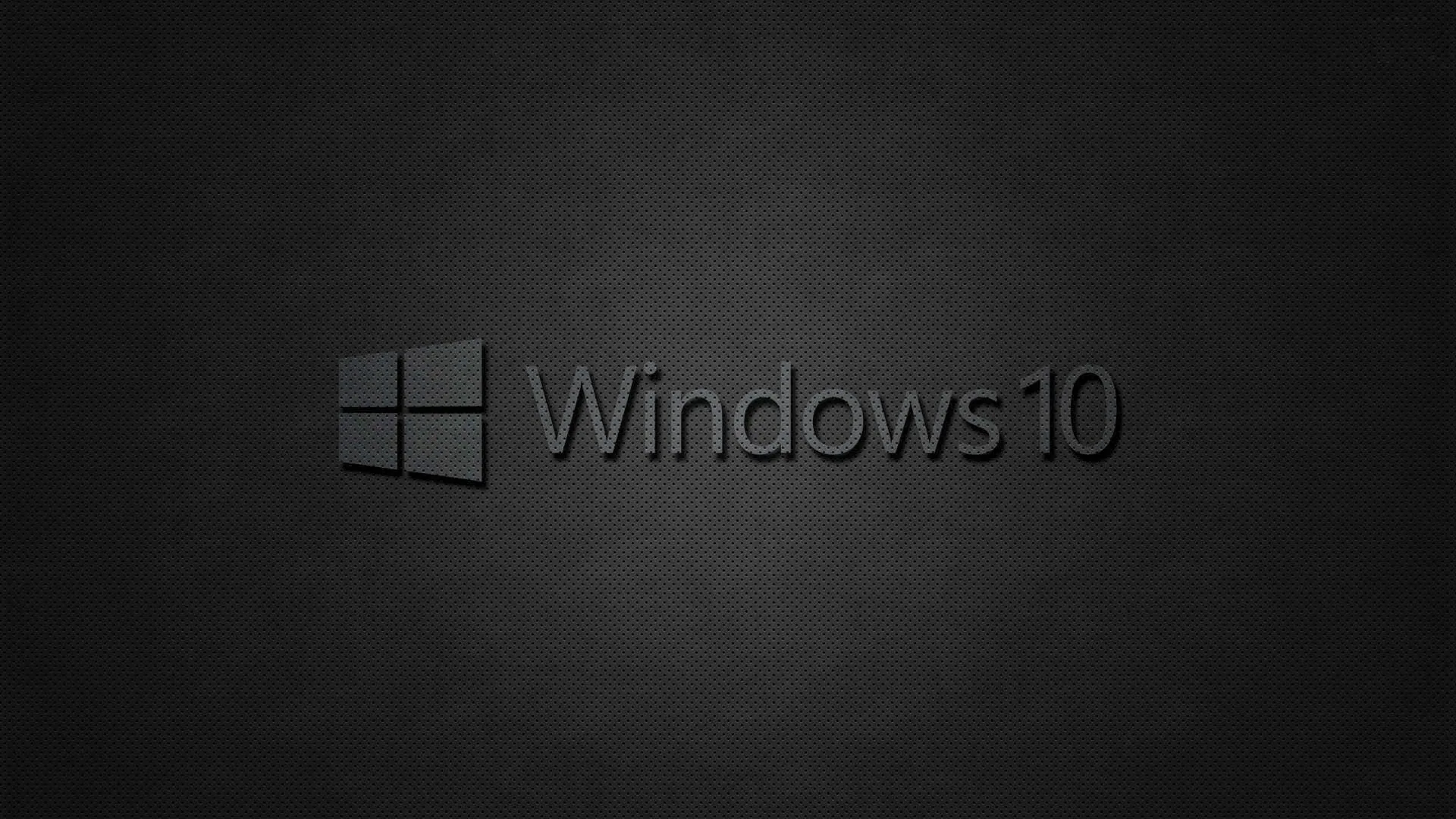 The grey Windows flag and Windows 10 wordmark centred on a woven dark fabric texture that fades toward black at the edges.