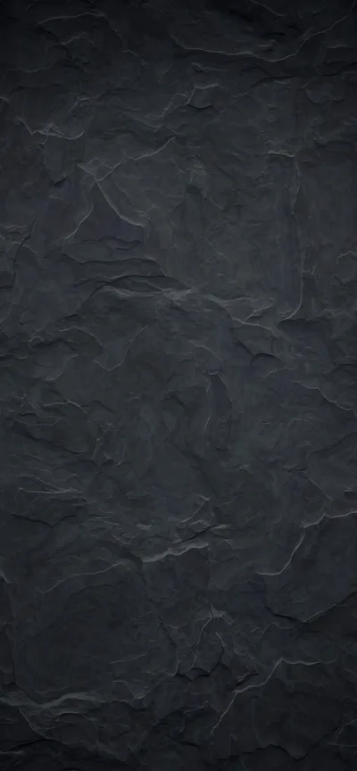 A tall slab of blue-grey slate with hairline veins running through it, the stone flaking in shallow layers down the right side.