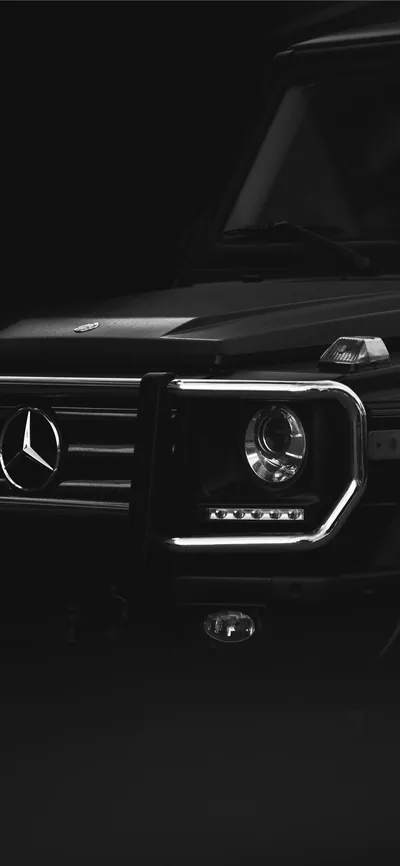 A tight vertical crop of the bull bar, three-pointed star and LED strip inside the headlight, everything above the bonnet left in black — sized for a phone screen.