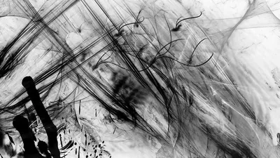Rough black brush strokes rake diagonally across a white ground, with a heavier blot anchoring the bottom left corner.