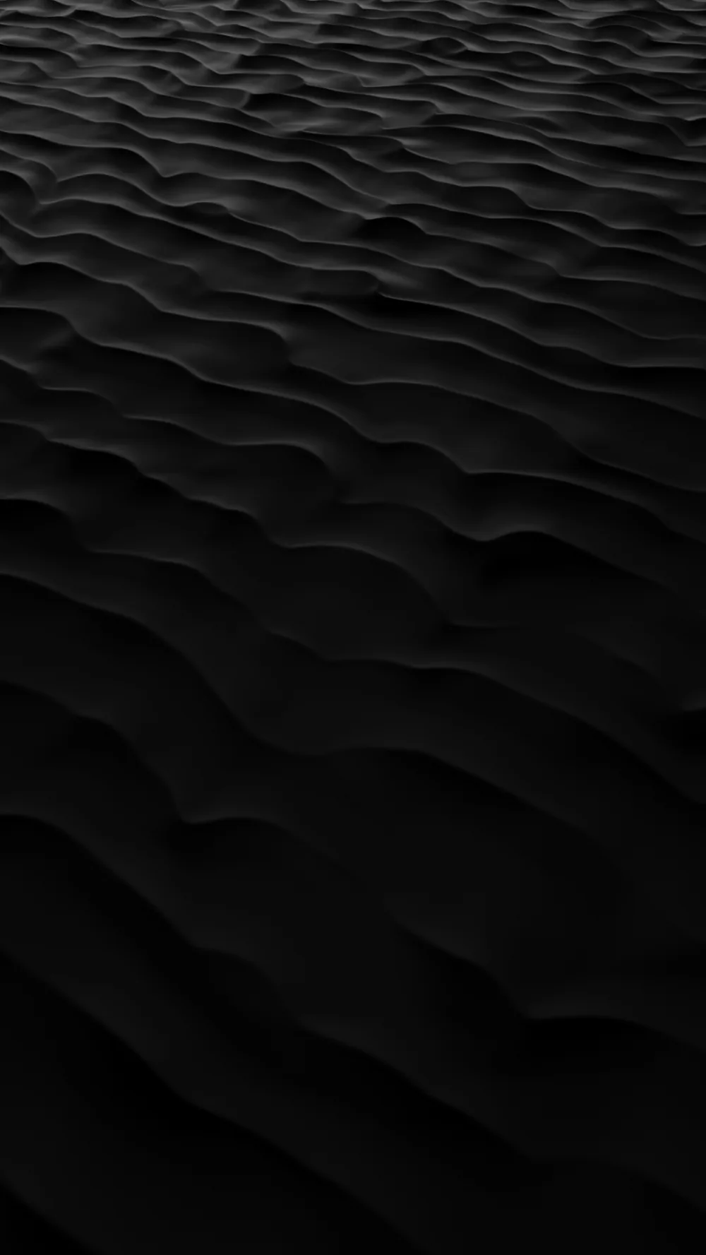 Wind ripples run in rows across dark sand shot from a low angle, the ridges catching light while the troughs stay unlit.